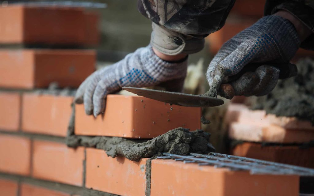 Expert stone masonry repair work showing stone replacement and mortar application | Oberer Construction Company Expert stone masonry repair work showing stone replacement and mortar application